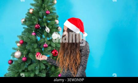 Ein junges festliches Model mit weihnachtsmann-Hut im Studio Stockfoto