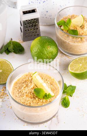 Frühstück Key Lime Über Nacht Haferbrei. Leckeres Vanillehaferbrei, mit Key Limette Topping und zerquetschten graham Cracker Krümeln, auf weißem Hintergrund mit Limette sl Stockfoto