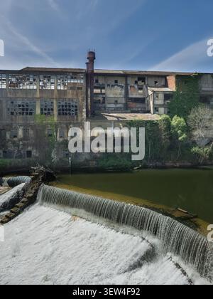 Die Fassade einer verlassenen Textilfabrik am Ufer des Flusses Nabao in Zentralportugal Stockfoto
