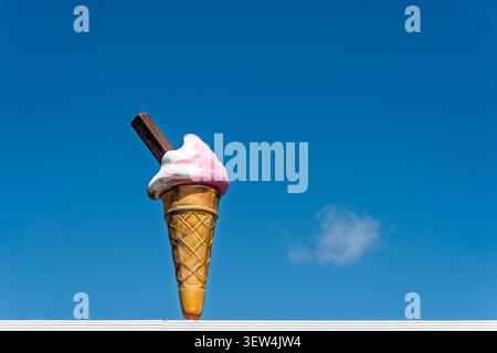 Riesiges Eiskegelschild mit rosafarbenem Erdbeerstrudel und Schokoladenflocke Stockfoto