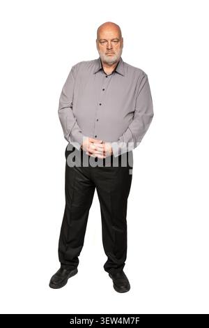 Durchgehendes Porträt eines seriösen 55-jährigen Mannes in grauem Hemd und schwarzer Hose Stockfoto