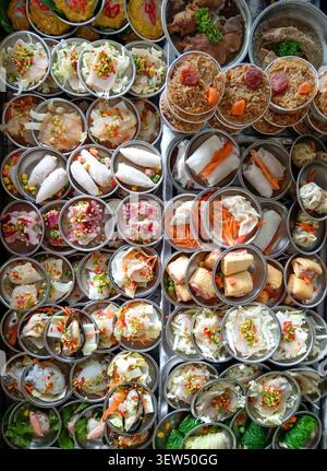 Verschiedene Arten von Dim-Sum-Knödeln und Gerichten in Thailand. Der Tisch ist mit kleinen Lebensmittelbehältern gefüllt. Stockfoto