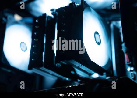 Detail des Innenraums eines professionellen Gaming-PCs. Motherboard, CPU-Turm-Kühler, Grafikkarte und RAM mit bunten RGB-LED-Lichtern. Stockfoto