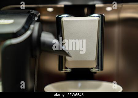 Frisch gebrühter Kaffee in einer Tasse aus der Espressomaschine. Heißes Morgengetränk mit cremigem Schaum. Barista-Stil-Getränk zu Hause oder im Café. Stockfoto