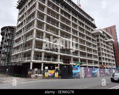 Ein großes mehrstöckiges Wohngebäude aus Beton in Liverpool, Großbritannien, das von Metallzäunen und Entwicklungshallen umgeben ist. Stockfoto
