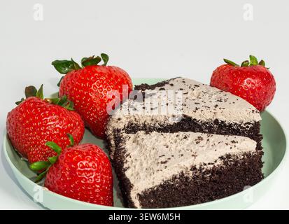 Ein Stück Schokoladenkuchen mit Waldbeeren und Erdbeeren. Stockfoto