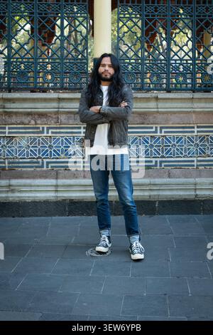 Junger Mann, der mit gekreuzten Armen im Kiosk morisco steht Stockfoto