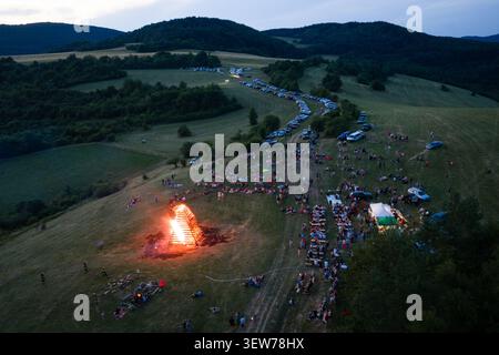 JEDLOVE KOSTOLANY, SLOWAKEI - 20. JUNI 2026: Hochwinkel-Drohnenansicht eines massiven brennenden Lagerfeuers während der Sommersonnenwende. Stockfoto