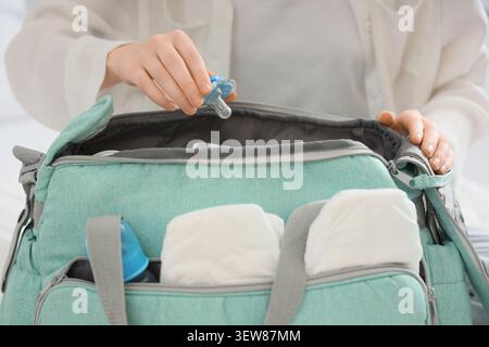 Person, die die Essentials für Babys in einer Windeltasche verpackt Stockfoto
