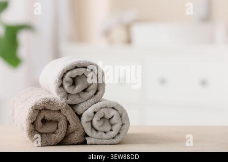Stapel gerollter neutraler Farbtücher auf Holzoberfläche Stockfoto