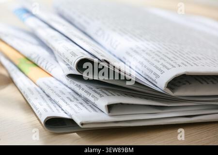 Stapel gefalteter Zeitungen auf Holzoberfläche Stockfoto