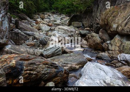 Das Flussbett Sanzhanxi in Taroko, Taiwan. Große Marmorblöcke füllen die felsige Schlucht. Ein kleiner Bach fließt durch die Berglandschaft. Stockfoto