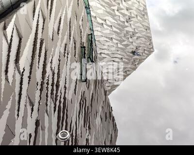 Reflexion der eckigen Aluminiumfassade des Titanic Belfast Museums in Belfast, Nordirland, auf einer Wasseroberfläche. Stockfoto