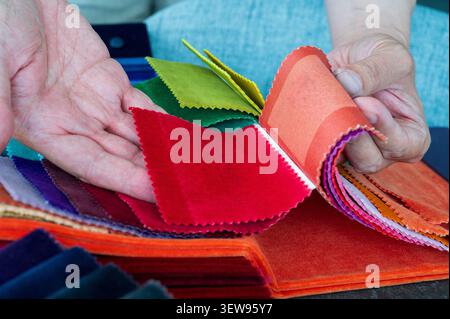 Hände halten farbenfrohe Samtmuster Musterkatalog für die Auswahl der Innenarchitektur Stockfoto