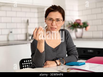 Die junge Frau macht Hausbuchhaltung an Einem Tisch Stockfoto
