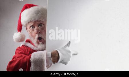 Der Weihnachtsmann hat auf eine leere Wand gezeigt Stockfoto