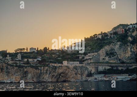 Sonnenuntergang über den Klippen von Taormina vom Ionischen Meer aus, Sizilien Stockfoto