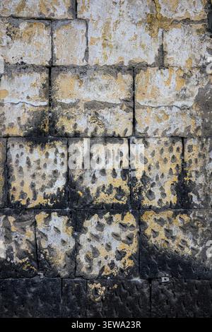 Verwitterte Steinmauer mit Moos und Flechten. Oberfläche zeigt Textur und Zerfall Stockfoto