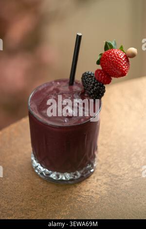 Eisgekühlter gemischter Beeren-Smoothie mit frischer Obstgarnitur. Stockfoto