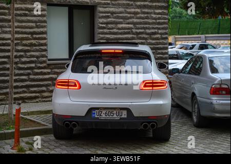 24. Juni 2026, Tiflis, Georgien Eine Rückansicht eines weißen Porsche Macan S SUV. Das Bild fängt das sportliche Heckdesign des Fahrzeugs ein, betont durch den Char Stockfoto