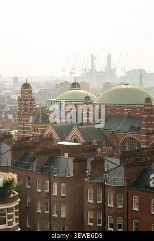 Ein Blick über Victoria, London, mit den ikonischen Kuppeln der Westminster Cathedral vor der trüben Silhouette des Battersea Power Station. Stockfoto