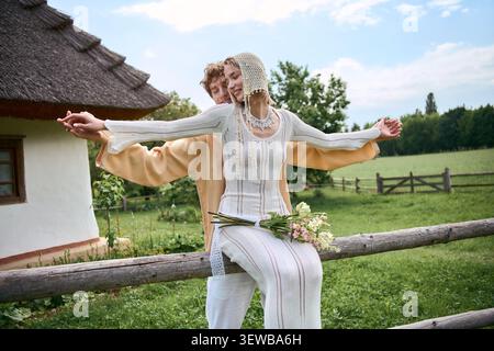 Elegantes Paar genießt eine liebevolle Umarmung in einer ruhigen ländlichen Umgebung voller Grün Stockfoto