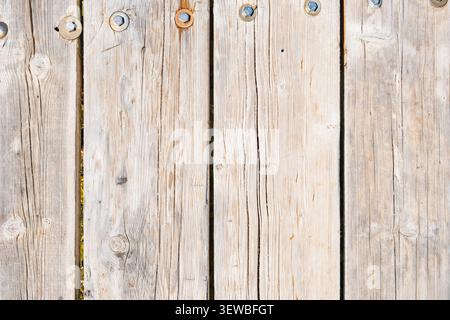 Nahaufnahme verwitterter Holzdielen mit sichtbarer Körnung und Textur. Einige Nägel sind vorhanden und zeigen Anzeichen von Alter und Verschleiß. Stockfoto