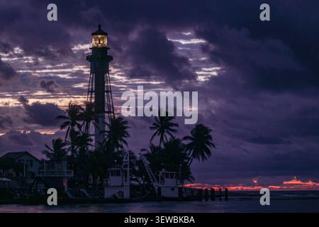 Hillsboro Inlet Lighthouse in der Nähe von Fort Lauderdale, Florida bei einem bewölkten Sonnenaufgang mit violettem und orangenem Himmel. Stockfoto