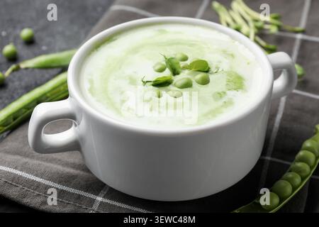 Leckere Erbsencremesuppe mit Mikrogrün auf dunklem Tisch, Nahaufnahme Stockfoto