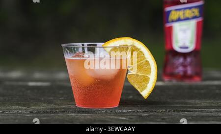 NORWALK, CT, USA - 26. JUNI 2026: Aperol spritzt Cocktail mit Eis und einer Orangenscheibe auf einem Holztisch Stockfoto