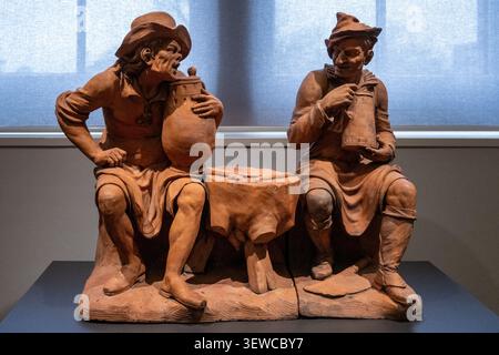 Amsterdam, Niederlande - 15. April 25: Terrakotta-Skulptur zweier sitzender Männer mit Krügen, ausgestellt im Rijksmuseum in Amsterdam, Niederlande. Stockfoto