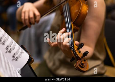 Nahaufnahme eines Musikers, der während eines Orchesterauftritts Geige spielt Stockfoto