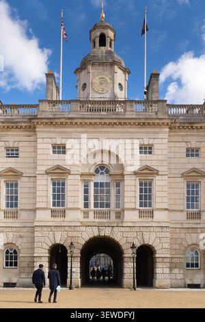 Die Menschen laufen durch den historischen Torbogen der Horse Guards in Whitehall, London, der als Tor zwischen der Straße und dem Park dient. Stockfoto