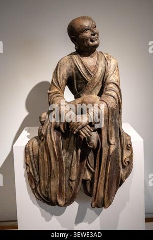 Amsterdam, Niederlande - 15. April 25: Geschnitzte sitzende Mönchfigur aus Holz in einer Galerie im Rijksmuseum in Amsterdam, Niederlande. Stockfoto