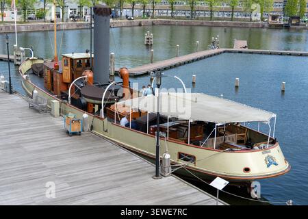Amsterdam, Niederlande - 15. April 25: Dampfschiff mit Schornstein an einem Jachthafen in Amsterdam, Nordholland, Niederlande. Stockfoto