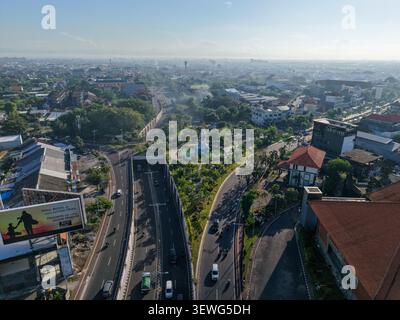 Aus der Vogelperspektive des Patung Titi Banda Monuments umgeben von üppigem Grün und Stadtstraßen in Kecamatan Denpasar Timur, Bali, Indonesien. Stockfoto