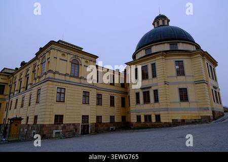 Stockholm, Schweden-27. November 2025: Kuppelpalastkapelle und gelbes Gebäude außen am Drottningholm-Palast unter bedecktem Himmel in Schweden. Stockfoto