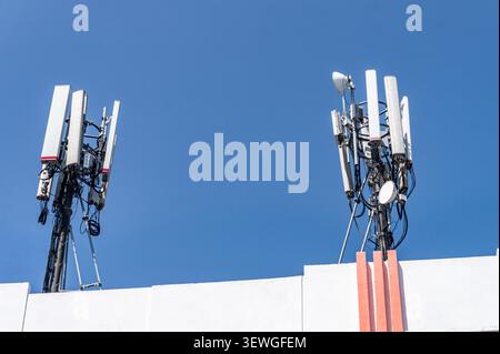 Weiße Panels und Antennen stehen hoch am Himmel. Auf Metallrahmen montierte Strukturen signalisieren starke Konnektivität. Ideal für Technik und Infrastruktur Stockfoto