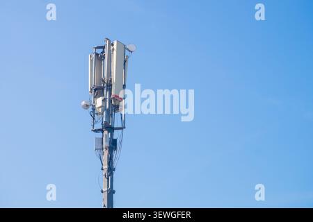 Weiße Panels und Antennen stehen hoch am Himmel. Auf Metallrahmen montierte Strukturen signalisieren starke Konnektivität. Ideal für Technik und Infrastruktur Stockfoto