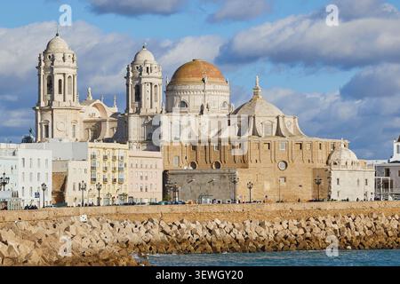 Felsige Küste entlang Campo del Sur und Cathedral de la Santa Cruz in Cadiz, Spanien. Stockfoto