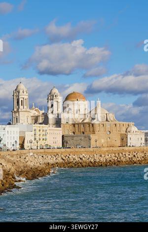Felsige Küste entlang Campo del Sur und Cathedral de la Santa Cruz in Cadiz, Spanien. Stockfoto