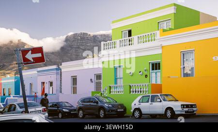 Eine lebhafte Reihe von pastellfarbenen und neonfarbenen Häusern entlang einer Straße im historischen Viertel Bo-Kaap, früher bekannt als Malay Quarter, zeigt das Archi Stockfoto