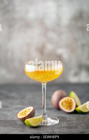 Martini-Cocktail mit Passionsfrucht. Saures alkoholisches Getränk mit frischem Passionsfrucht und Limette, mit Barwerkzeugen. Stockfoto