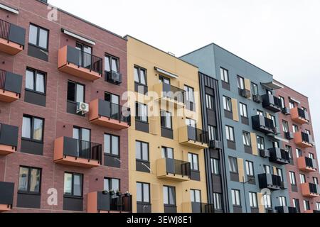 Moderne Wohnhausfassade mit geometrischen Balkonen, Ziegelwänden und zeitgenössischem Apartmentblock-Design. Stockfoto