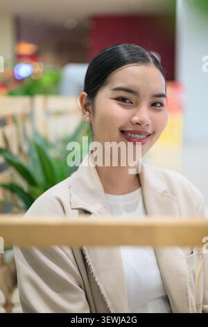 Ein professionelles Nahaufnahme-Porträt einer fröhlichen jungen südostasiatischen thailändischen Geschäftsfrau aus der Isan-Region, die mit Zahnspangen weit lächelt. Verschleiß Stockfoto