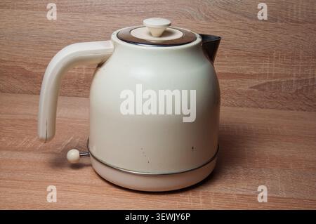 Vintage cremefarbenes elektrisches Wasserkocher mit Retro-Design auf einem Holz-Hintergrund Stockfoto