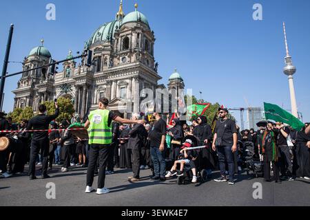 Berlin, Deutschland. Juni 2026. Die Teilnehmer marschieren mit religiösen Fahnen vor dem Berliner Dom während der jährlichen Aschura-Prozession in Berlin am Samstag, 27. Juni 2026. Die Prozession erinnert an Ashura, eine bedeutende schiitische muslimische Begehung, die das Martyrium von Imam Hussein markiert. (Foto: Michael Kuenne/PRESSCOV/SIPA USA) Credit: SIPA USA/Alamy Live News Stockfoto