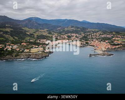 Ein Weitwinkelfoto fängt das malerische Küstendorf Collioure in Frankreich ein, eingebettet zwischen sanften grünen Bergen und dem tiefblauen Mediter Stockfoto