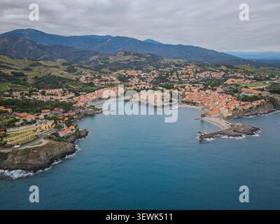 Eine weite Aufnahme aus der Luft zeigt die malerische Küstenstadt Collioure, Frankreich, mit Terrakottadächern, die um eine Bucht gruppiert sind. Die Tiefe Stockfoto