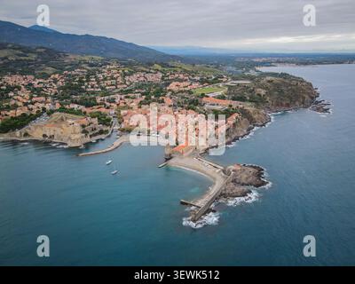 Ein weites Luftbild fängt die malerische Küstenstadt Collioure, Frankreich, mit ihren Terrakottadächern, dem historischen Königsschloss, Stockfoto